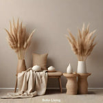 Boho-Wohnszene mit Pampasgras in Vasen, Holzbank, weichen Textilien und Keramikdekoration in warmen Beigetönen.