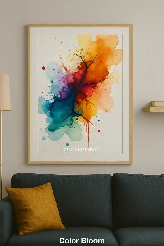Gerahmte abstrakte Aquarellkunst mit bunter Farbexplosion und schwarzer Aststruktur – über grünem Sofa mit Senfkissen.